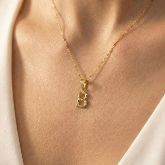 Gold color bamboo texture initial necklace letter pendant on model, minimalist personalized jewelry for mothers day gift.