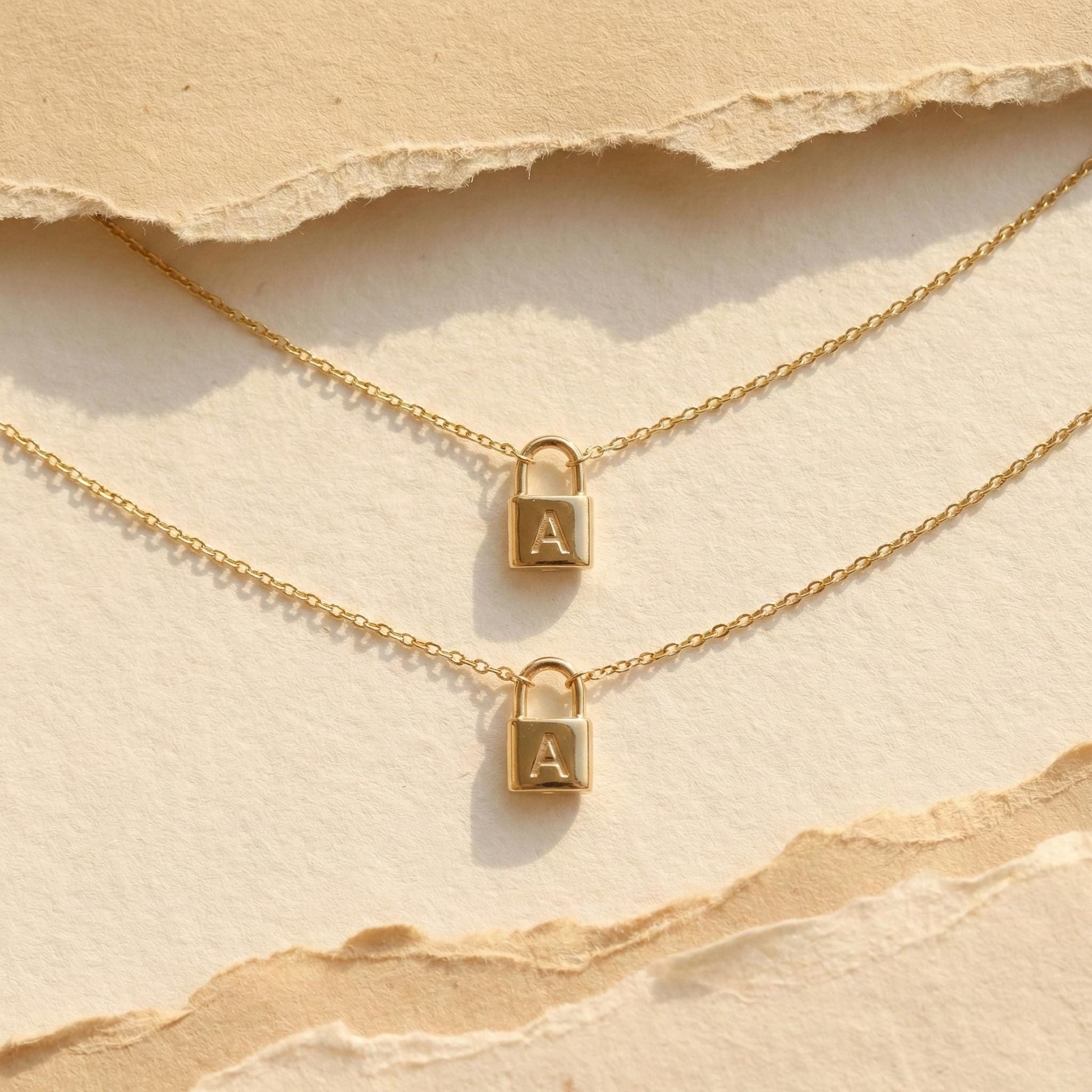 Gold padlock necklace with engraved initial letter A, dainty minimalist personalized jewelry gift for her, Mother's Day custom pendant on model.