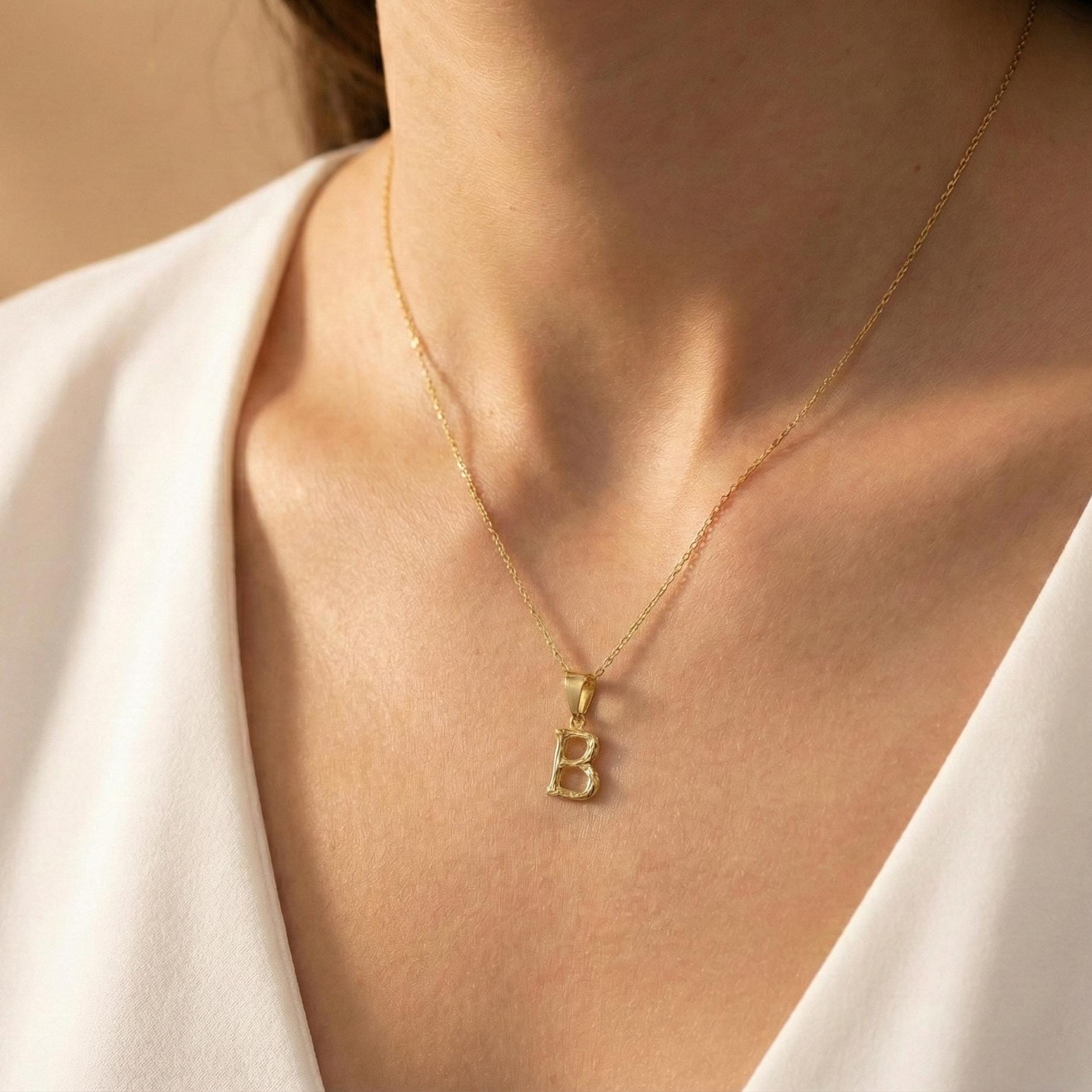 Gold color bamboo texture initial necklace letter pendant on model, minimalist personalized jewelry for mothers day gift.