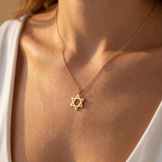 Minimalist gold Star of David pendant necklace on a woman's neck, dainty Magen David Jewish jewelry gift for Bat Mitzvah and Mother's Day.