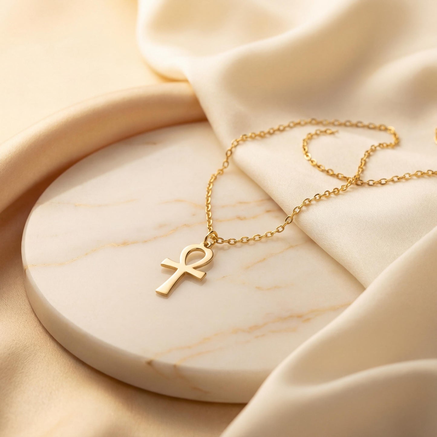 Minimalist Ankh necklace worn by a woman, dainty Egyptian cross key of life pendant resting on chest in natural sunlight, elegant everyday jewelry.