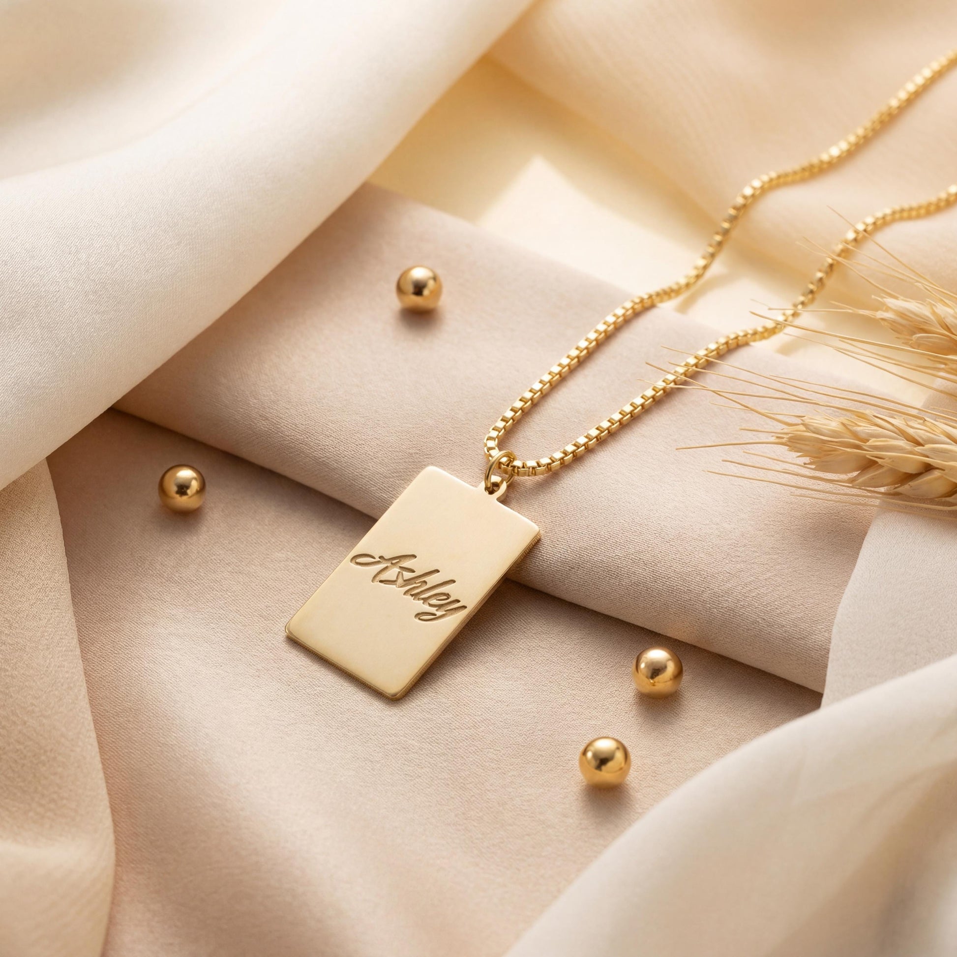 Gold vertical bar necklace on a model's neck, personalized with the engraved name Ashley in cursive font. Minimalist rectangular pendant gift for mother's day.
