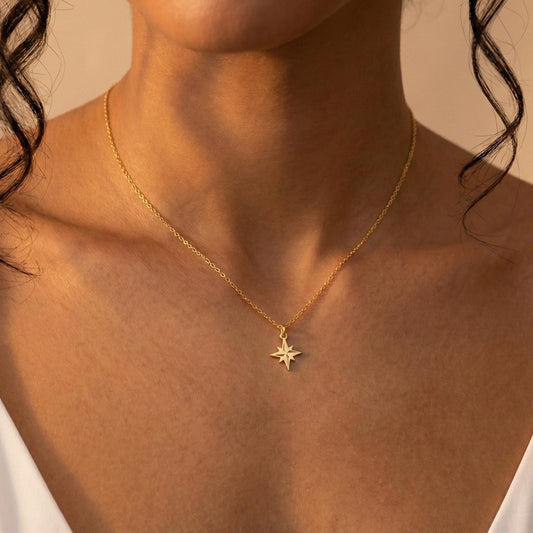 Gold North Star necklace on model, minimalist celestial jewelry pendant, eight-pointed starburst charm necklace, dainty layering necklace gift for her, mothers day and graduation jewelry gift idea