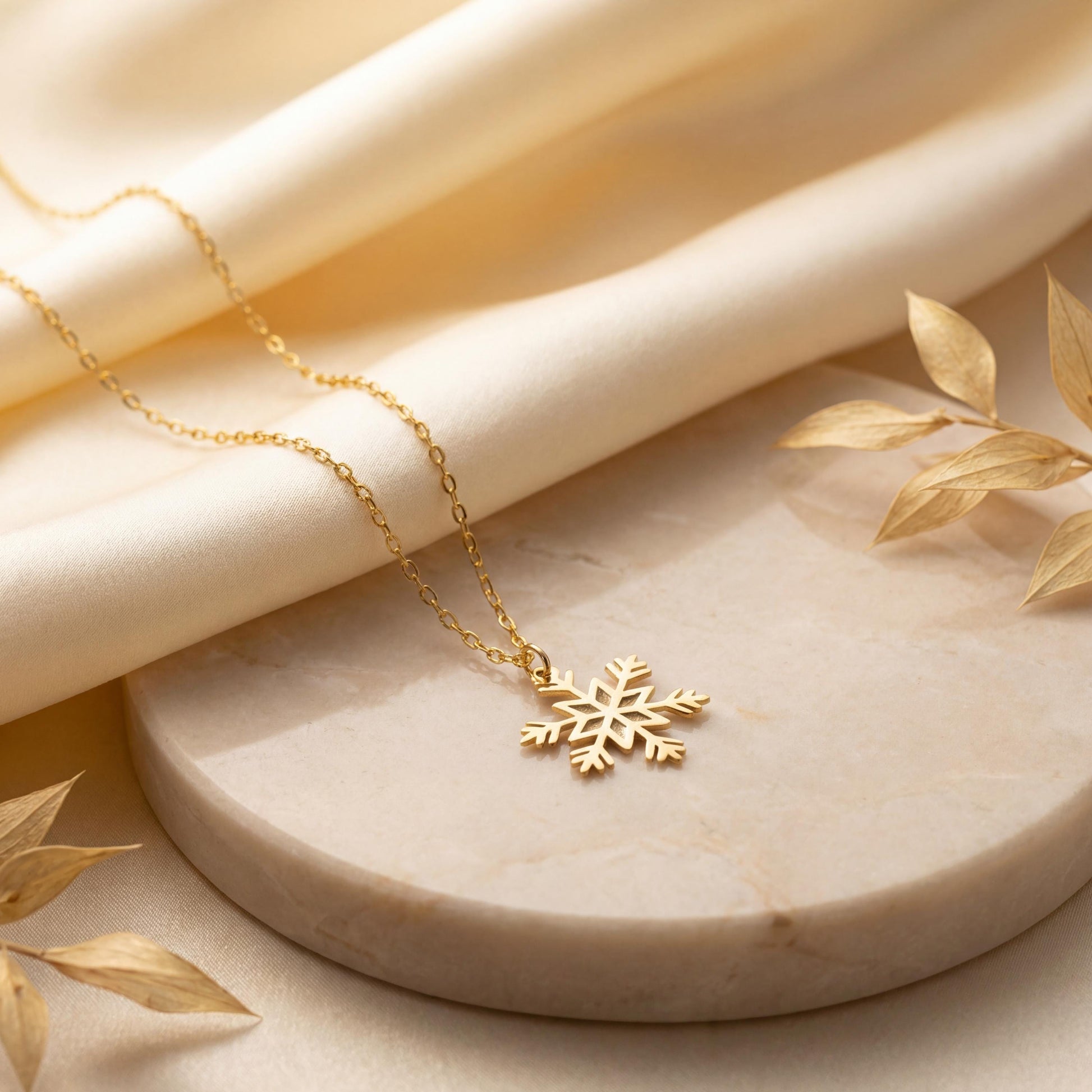 Dainty 14K gold plated snowflake pendant necklace resting elegantly on a woman's collarbone, showing a minimalist geometric jewelry design perfect for a unique Mother's Day gift or layered everyday wear.